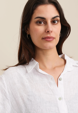 Woman wearing a white shirt against a plain background