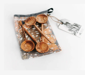 Set of wooden spoons on a patterned cloth with a tag on a white background
