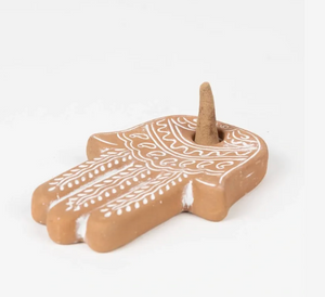 Decorative ceramic hamsa hand with white patterns on a white background