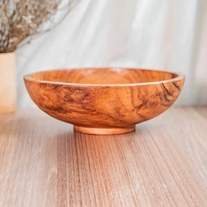 Wooden bowl on a wooden surface with a blurred background
