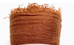 Brown textured fabric with frayed edges on a white background