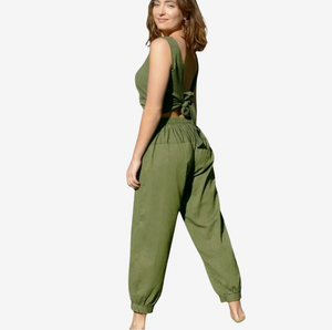 Woman wearing green pants and matching top on a white background
