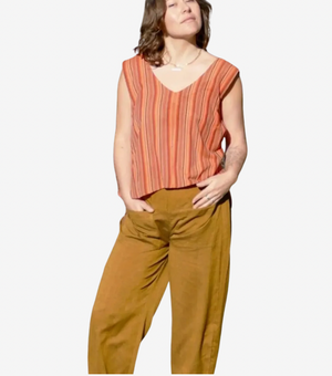 Woman wearing a striped orange top and brown pants on a white background