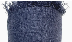 Close-up of textured blue fabric with frayed edge on a white background