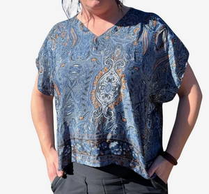 Person wearing a blue patterned shirt against a white background