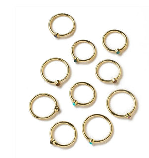 Gold rings with small gemstones on a white background