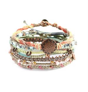 Stack of colorful wrap bracelets with a central copper-colored medallion on a white background
