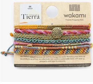 Set of colorful bracelets on a Wakami branded card with text about the brand's mission.