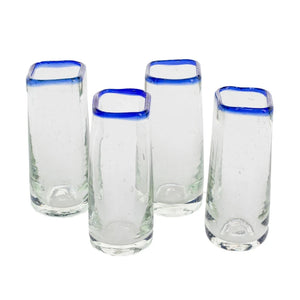 Set of four shot glasses with blue rim on a white background
