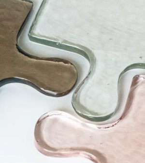 Close-up of multicolor glass tile with a wavy edge on a white background
