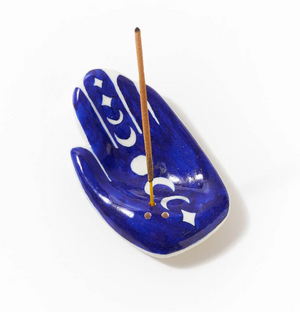 Blue ceramic incense holder with white patterns and a single incense stick on a white background