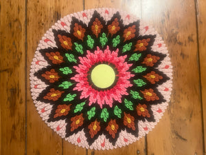 Colorful crocheted mandala on a wooden surface
