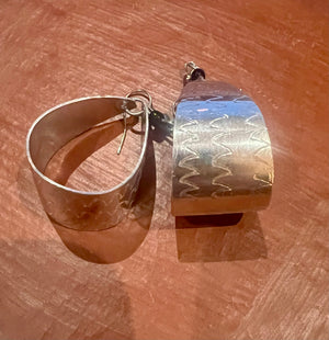 Silver and gold earrings on a wooden surface