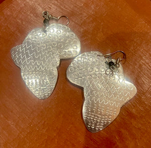 Silver Africa map earrings on a brown surface