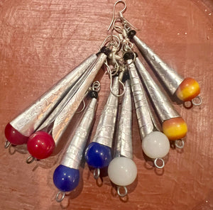 Earrings with metallic cones and colorful beads on a wooden surface