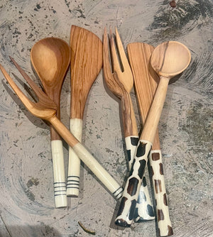 Set of wooden utensils with animal print handles on a textured surface