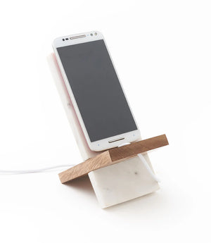 Smartphone on a marble and wood phone stand on a white background