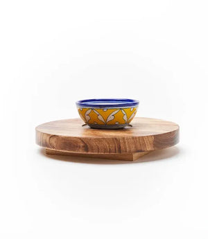 Wooden round cheese board with a ceramic bowl on a white background