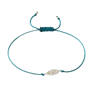 Teal braided bracelet with a silver eye-shaped charm on a white background