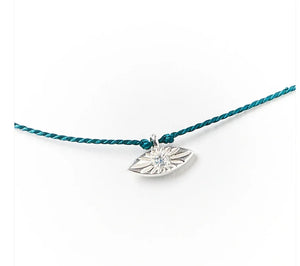 Silver eye-shaped pendant with a blue cord on a white background