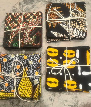 Four fabric pieces with various patterns tied together on a textured surface