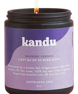 Close up of lit Kandu lavender cypress candle on white background