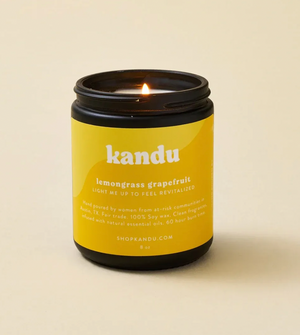 Kandu candle with a yellow label on a beige background