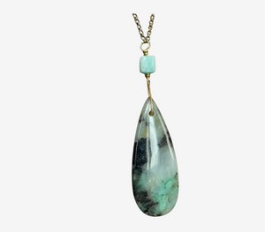 Teardrop-shaped gemstone pendant on a chain against a white background