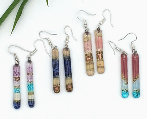 Set of colorful cylindrical glass earrings on a white background