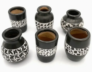Set of six black ceramic vases with geometric patterns on a white background