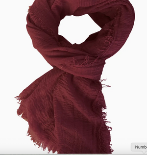 Maroon scarf with frayed edges on a white background