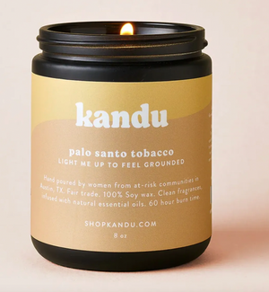Kandu Palo Santo Tobacco candle with a beige label on a light pink background