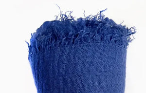 Blue textured fabric with frayed edges on a white background