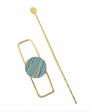 Gold hairpin with a striped circular design on a white background