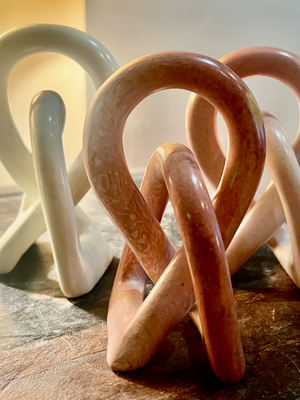 Set of ceramic sculptures in various colors on a wooden surface