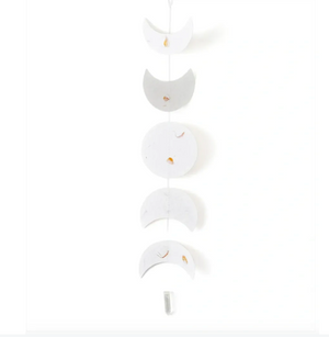 Decorative hanging with white crescent moon shapes on a white background