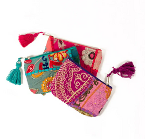 Colorful patterned pouches with tassels on a white background