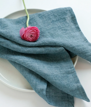 Blue napkin with a pink flower on a white plate