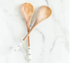 Two wooden utensils on a white marble surface