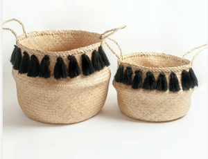 Two woven baskets with black tassels on a white background