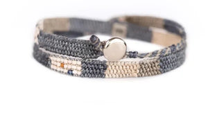 Multistrand bracelet with a round metal clasp on a white background