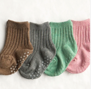 Four pairs of toddler socks in brown, gray, green, and pink on a white background