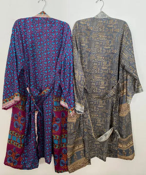 Two patterned robes hanging on a white background