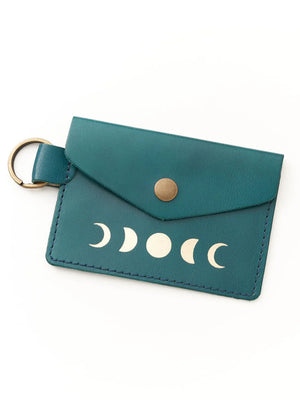 Teal leather cardholder with moon phase design on a white background