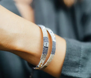 Close-up of a wrist wearing multiple bracelets with a blurred background