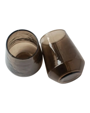 Two brown glass tumblers on a white background