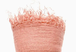 Peach textured fabric with frayed edges on a white background