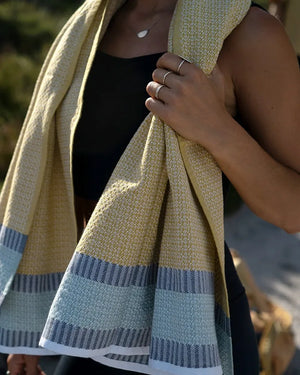 Person holding a striped towel with a blurred natural background