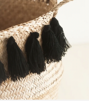 Black tassels hanging from a straw basket