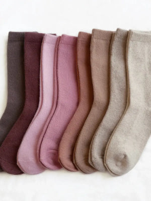 Set of eight pairs of socks in various shades of brown and pink on a white background